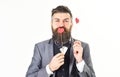 Bearded man holds red hearts. Kiss, love, romance, fashion, style, celebration, emotions, feelings, flirt concept.