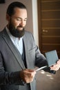 Bearded man holds a ticket and passport in his hands