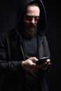 Bearded Man in Hood looking at smartphone