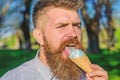 Bearded man with ice cream cone. Chilling concept. Man with long beard licks ice cream, close up. Man with beard and Royalty Free Stock Photo