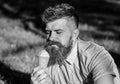 Bearded man with ice cream cone. Temptation concept. Man with beard and mustache on calm face enjoy ice cream, grass on