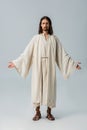 Bearded man in jesus robe standing with outstretched hands on grey