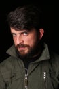 Bearded man in khaki jacket with interesting look. Close.up. Black Royalty Free Stock Photo