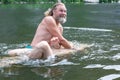 a bearded man dips a man in the water. rite of blessing, baptism. Ceremony Of A Christening outdoor Royalty Free Stock Photo