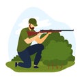 Bearded man kneeling with rifle outdoors. Hunter aiming gun with focus, green foliage background. Hunting sport and Royalty Free Stock Photo