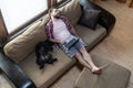 Bearded man with a laptop fell asleep on a soft sofa, next to him funny, belly up, lies his dog Schnauzer, in natural Royalty Free Stock Photo