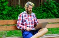 Bearded man with laptop working outdoors. Businessman with notebook in park. Study and work online.