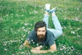 Bearded man laying on green grass