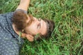 Bearded man laying on green grass