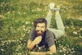 Bearded man laying on green grass smiling