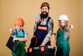 Bearded man with little girls. Father and daughter in workshop. Repairman in uniform. Foreman. construction worker