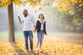 Bearded man looking into his phone while holding hand of girlfriend Royalty Free Stock Photo