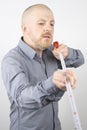 Bearded man makes a measuring tape measure centimeter Royalty Free Stock Photo