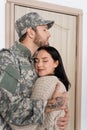 bearded man in military uniform hugging