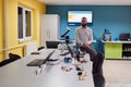 A bearded man in a modern robotics laboratory, immersed in research and surrounded by advanced technology and equipment