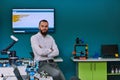 A bearded man in a modern robotics laboratory, immersed in research and surrounded by advanced technology and equipment
