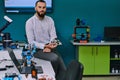 A bearded man in a modern robotics laboratory, immersed in research and surrounded by advanced technology and equipment