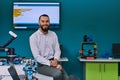 A bearded man in a modern robotics laboratory, immersed in research and surrounded by advanced technology and equipment