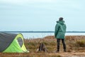 A bearded man near a camping tent in green on the background of nature and the lake. The concept of travel, tourism, camping Royalty Free Stock Photo