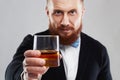 Bearded man offers whiskey.Elegant man keeps and holds a glass