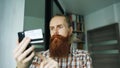 Bearded man online shopping and banking with credit card using smartphone at home Royalty Free Stock Photo