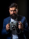 Bearded man with photo retro camera. Portrait of serious man photographer with vintage retro old film camera isolated on