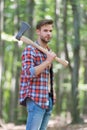 Bearded man in plaid shirt with jeans carry large splitting axe in summer wood natural environment, lumberjack Royalty Free Stock Photo