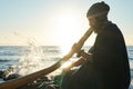 Bearded man playing his didgeridoo Australian instrument in sunshine at seashore. Royalty Free Stock Photo