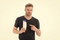 Bearded man point finger at shampoo or gel bottle. Macho with beard in tshirt show cosmetic for bath or shower