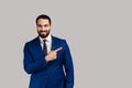 Bearded man pointing finger away with toothy smile on face, empty space for your advertisement. Royalty Free Stock Photo