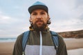 Bearded man portrait outdoor brutal guy wearing cap walking with backpack travel lifestyle Royalty Free Stock Photo