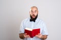 Bearded man reading a book in front of gray background Royalty Free Stock Photo