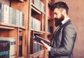 Bearded man reading book in the librar