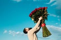 Bearded man with red rose bouquet. Valentine& x27;s day. Gift with love. Handsome man on background sky. Gift on Royalty Free Stock Photo