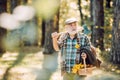 Bearded man relax in forest. Smiling old forester with axe and flowers. Happy man with beard and mustache hold axe