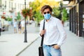 Bearded man in safety mask on the street. Handsome guy with medical mask after work during quarantine