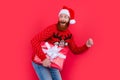 Bearded man in Santa hat holding present box. HappySanta Claus delivering present. New Year present