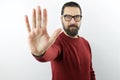 Bearded man with serious face wearing casual clothes and glasses doing stop sign with palm of the hand. Royalty Free Stock Photo