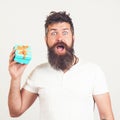 Bearded man with shocked facial expression. Man shows gift box. Hipster surprised by best present ever. Sale concept. Brutal