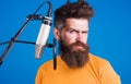 Bearded man sing in condenser microphone. Male Professional vocalist. Singing in studio. Karaoke. Royalty Free Stock Photo