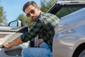 Bearded man sitting in the car with open door and looking at the camera Royalty Free Stock Photo