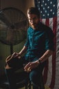 Bearded Man sitting in dark room with American Flag