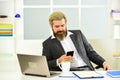 bearded man sitting at desk in office. confident brutal businessman. Elegant businessman analyzing data in smartphone
