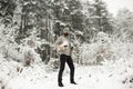 Bearded man with skates in snowy forest.