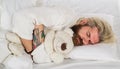 Bearded man sleeping at bedroom and hugging soft teddy bear. Handsome male sleeping with plush teddybear relaxing in bed Royalty Free Stock Photo