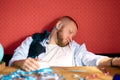 Bearded man sleeping at table in messy room with girls underwear, brassiere after bachelor party
