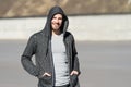 Bearded man smile in hood on sunny outdoor, fashion. Macho happy smiling in sweatshirt, casual style. Mens fashion, style, sportsw Royalty Free Stock Photo