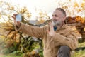 man in speshial boots reaching the destination and resting under tree and taking photos on phone in Peak District at Royalty Free Stock Photo