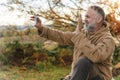 man in speshial boots reaching the destination and resting under tree and taking photos on phone in Peak District at Royalty Free Stock Photo