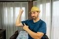 Bearded man in a straw hat dressed in a dark blue shirt with a shocked expression in the living room at home Royalty Free Stock Photo